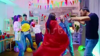 在她的朋友聚会上，放大了一个打扮成超级英雄的女孩的镜头，穿着红色斗篷。