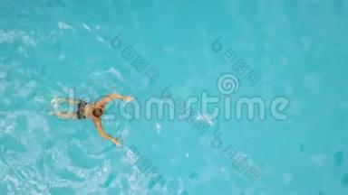 年轻人在漂浮的游泳池里游泳。 从上面的飞行无人机男子游泳池景。 水上<strong>运动</strong>