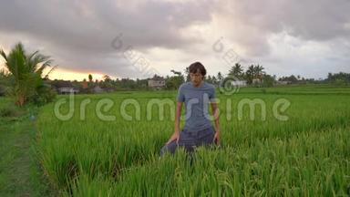 一个年轻人在一个美丽的稻田上进行瑜伽训练。 旅游亚洲概念。 慢动作视频