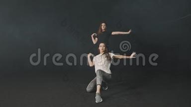 两名年轻女子在黑暗工作室训练同步舞蹈<strong>编排</strong>