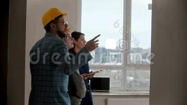 一位年轻的孕妇和她丈夫在一栋新楼的公寓里和一位房地产经纪人谈话
