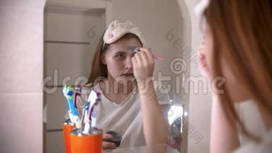 年轻女子用刷子在脸上敷面膜