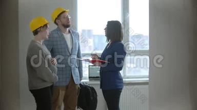 一名孕妇和丈夫在一栋新<strong>楼</strong>的公寓里和一名<strong>房地产</strong>经纪人谈话