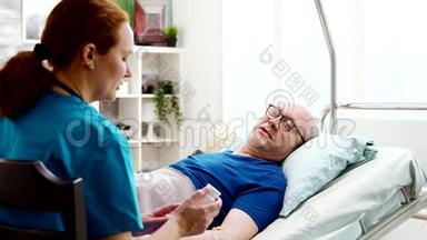养老院护士给躺在<strong>病床</strong>上的病人开处方药