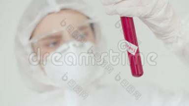 一位年轻的女科学家检查一个带有生物危险的红色物质的试管。 戴<strong>防</strong>护<strong>眼镜</strong>的女孩