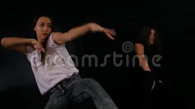 两个年轻女子在黑暗的室内自由式舞蹈