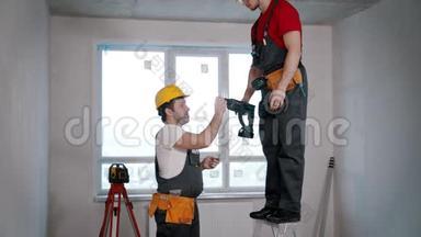 公寓维修-一名工人把钻头传给另一名工人