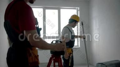 修理草稿公寓-两名工人工作-激光指针和测量东西