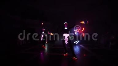 激光LED显示。 艺术家在黑暗的房间里展示舞蹈和激光表演。 衣服<strong>散发</strong>着冰和激光的<strong>光芒</strong>。 夜晚