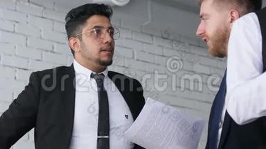 两个男人在<strong>工作中</strong>的对话，穿西装的年轻商人在办公室里一起<strong>工作</strong>和交流。 公司法人