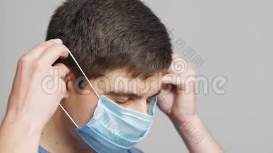 灰色工作室背景、概念医学与希望、专科专科医生，戴防护口罩的严肃年轻医生