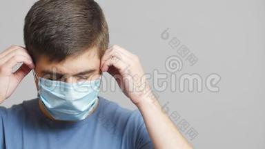 精疲力竭的医务工作者在灰色的工作室背景上戴上医疗和努力工作的面具，概念医学努力，为我而战