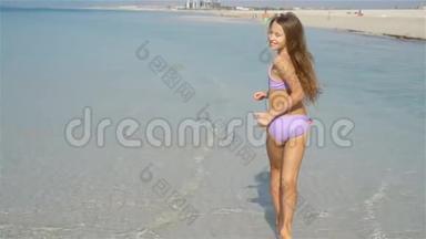 暑假期间海滩可爱的活泼小女孩