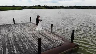 新郎新娘拥抱在木墩上的空中飞行。 相机绕着圈转
