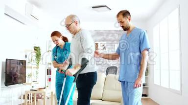 一队护士或<strong>社会工作</strong>者帮助一位老人拄着拐杖走出疗养院