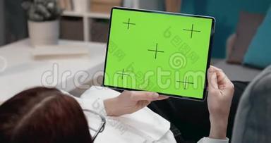 妇女滚动数字平板电脑空屏的后视图