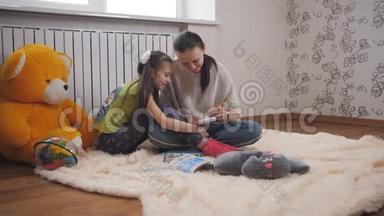 母亲和小女儿躺在客厅温暖的地板上，用彩色<strong>铅笔</strong>在记事本上<strong>画画</strong>。