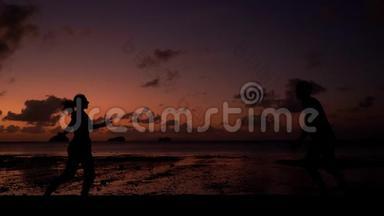 一对夫妇在日落时沿着热带海滩散步。 浪漫的气氛。 一起跑吧