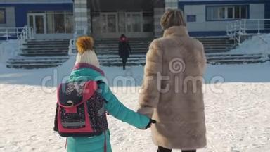 妈妈在冬天护送女儿上学。