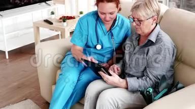 <strong>帮助</strong>老年退休妇女<strong>使用</strong>平板电脑的女护士
