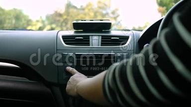 阳光明媚的一天，年轻女子开着一辆车，在车上转动收音机按钮。