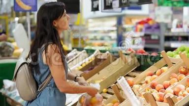 一个年轻的女人在<strong>超市</strong>买<strong>水果</strong>。