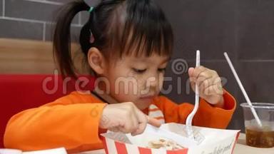 亚洲同胞小女孩喜欢吃炸鸡，薯条和花蜜在服务商店与她的家人。 <strong>肯德基</strong>是一家