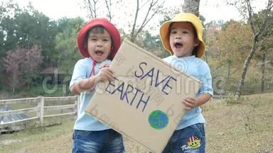 两个小女孩兄弟<strong>姐妹</strong>抱着`拯救地球`<strong>海报</strong>显示了抗议森林中塑料污染的标志。