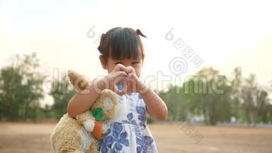 <strong>可爱</strong>的亚洲小女孩拥抱兔子<strong>娃娃</strong>与微笑的脸在公共公园。