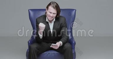 这位穿着黑色西装的英俊青年坐在椅子上，他兴奋地说，股市游戏，汇率下跌，野蛮人