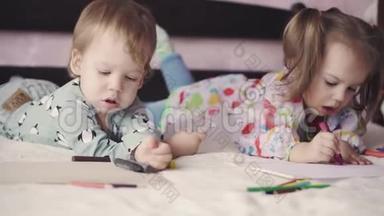 两个<strong>可爱</strong>的孩子用躺在床上的绉纱<strong>画画</strong>。 女孩和男孩用铅笔在床上玩。 兄弟姐妹双胞胎
