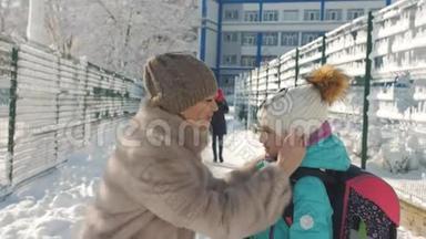 妈妈给一个小女儿调帽子，然后送她去上学冬雪日。
