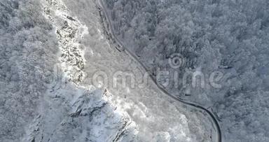 阳光明媚的悬崖和<strong>积雪覆盖</strong>着森林，道路贯穿其中。 冬季景色