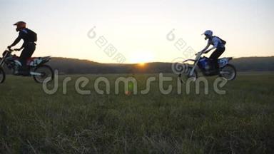 骑摩托车的人骑摩托车穿过田野，对抗日落。 积极休息的朋友户外驾驶能力强
