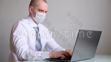 穿着医用口罩和办公室服装、白衬衫和领带的人在笔记本电脑上远程从家里谈生意。 关于