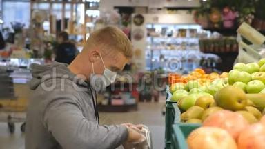 带医用口罩的人在商店里挑选苹果。 男人在超市里选择水果。 购买农产品