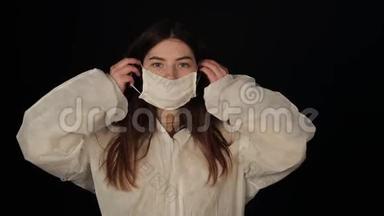 <strong>年</strong>轻的女科学家穿着医用防护服，西装，<strong>口罩</strong>，手套。 孤立的黑色背景。 冠状病毒