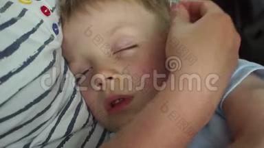 一个小男孩在旅途中`汽车或公共汽车里抱着妈妈睡觉，特写镜头