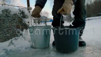 一个冬天有水桶的老人从井里提水。