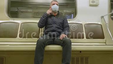 男子坐在移动<strong>地铁车厢</strong>的正面，脸上戴着医疗面罩，以保护自己免受感染。
