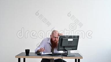 穿着衣服的疯狂商人在办公室里打破了他显示器上的键盘。 他在工作上有问题