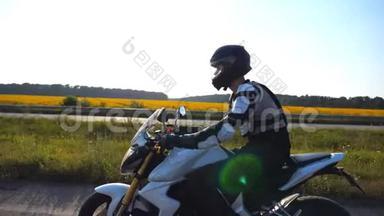 戴着头盔的人骑着摩托车沿着高速公路快速行驶，在背景下可以看到风景。 超速行驶的摩托车手