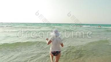 年轻的白种人女士穿着<strong>泳装</strong>和夏帽在海水中飞溅。 海洋<strong>海滩</strong>度假。 慢慢慢慢