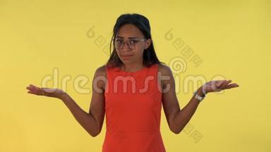 混合种族的年轻女子摊开双手向两边`说黄色背景下的`