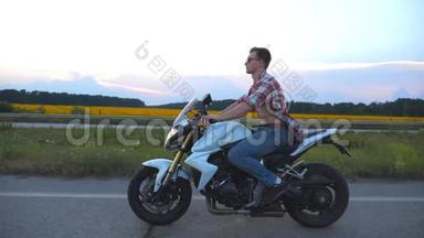 骑着现代摩托车的年轻人。 穿着衬衫戴眼镜驾驶摩托车的帅气摩托车