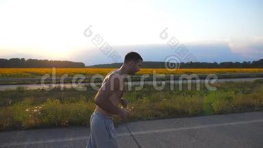 日落时分，年轻的肌肉男在乡间小路上慢跑。 马拉松<strong>长跑</strong>户外男子慢跑训练概况。 <strong>运动员</strong>