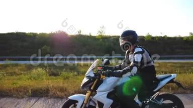 一个戴着头盔的男人在高速公路上开着一辆强劲的运动摩托车。骑摩托车穿越乡间公路的摩托车手
