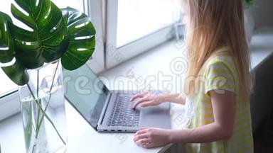 金发小女孩在笔记本电脑上工作、学习或玩耍。 按<strong>手指</strong>按<strong>按钮</strong>。 数字教育