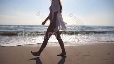 无法辨认的女人走在海边。 年轻美丽的女孩享受生活，踏在海边