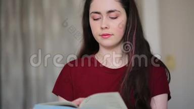 那个女人盘腿坐在床上翻阅一本书。 摄像机从上到下，从